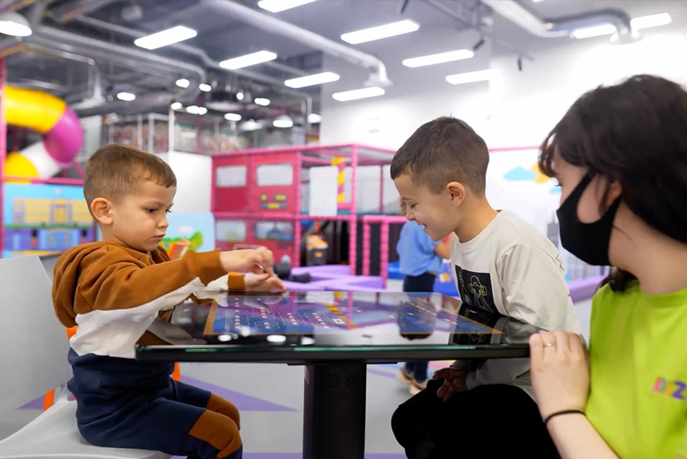 Kids playing interactive games on restaurant touch screen table